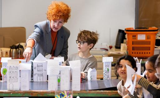 Museumles waarbij de juf iets uitlegt aan een jongen.