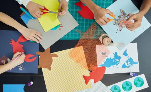 Kinderen zitten om een tafel en knutselen.